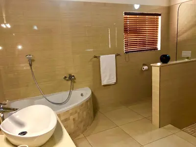 a bathroom with a tub and a toilet and a sink at Golden Impalas Bush Resort in Hammanskraal