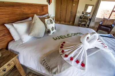 a bedroom with a bed with towels on it at Golden Impalas Bush Resort in Hammanskraal