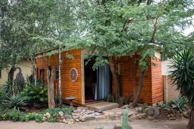 a small brick house with a porch and a bench at Blyde Africa- Cottage in Benoni