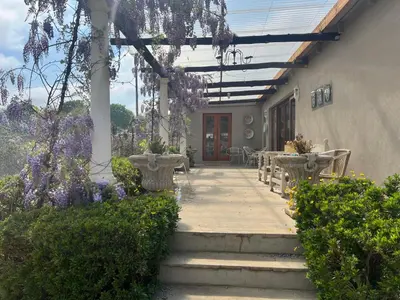 a patio with a table and chairs and purple flowers at Apple and Rose in Belfast