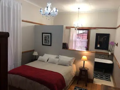 a bedroom with a bed and a chandelier at Apple and Rose in Belfast