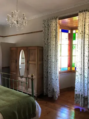 a bedroom with a bed and a mirror and a window at Apple and Rose in Belfast