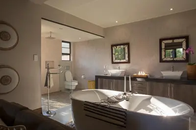 a large bathroom with a tub and two sinks at Moya Safari Villa in Hoedspruit