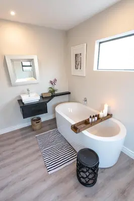 a bathroom with a large white tub and a sink at Moya Safari Villa in Hoedspruit
