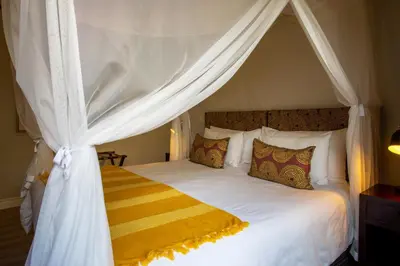 a bedroom with a white bed with a canopy at Moya Safari Villa in Hoedspruit