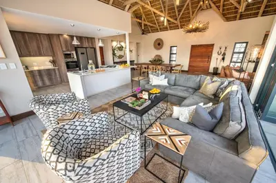 an open living room with a couch and chairs at Moya Safari Villa in Hoedspruit