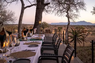 a long table with chairs and a view of the desert at Tomo Safari Lodge in Hoedspruit