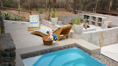 a swimming pool with a slide and a playground at Dream of Africa Bush Lodge in Marloth Park
