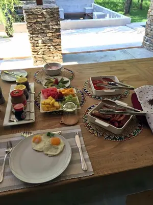 a wooden table with plates of food on it at Dream of Africa Bush Lodge in Marloth Park