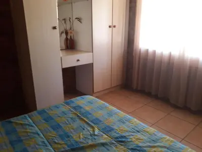 a bedroom with a bed and a dresser and a window at Eagle's Crest in Marloth Park