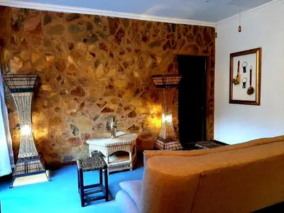 a living room with a couch and a table at Rocky Hollow Lodge in Pretoria