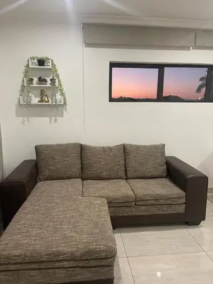 a brown couch in a living room with a window at Sweet Home Alibama in Nelspruit
