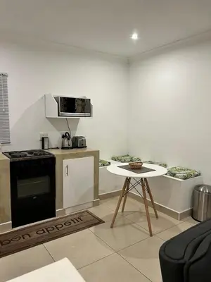 a kitchen with a stove and a table in a room at Sweet Home Alibama in Nelspruit