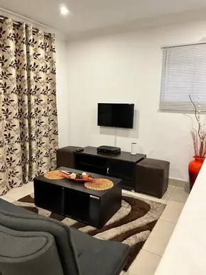 a living room with a tv and a table at Sweet Home Alibama in Nelspruit