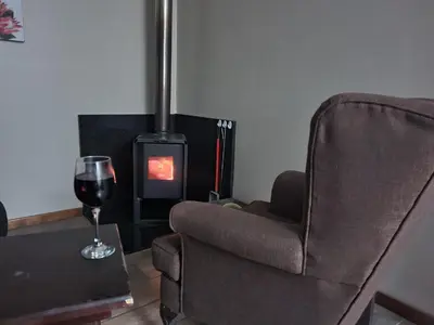 a chair and a glass of wine next to a fireplace at Forest View Cabins in Tzaneen
