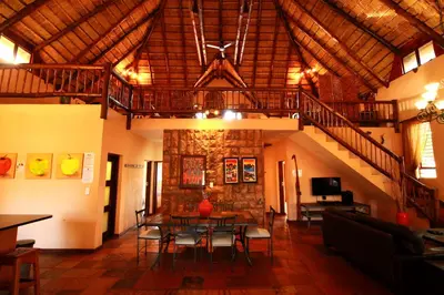 a dining room with a table and chairs and a staircase at Makhato Bush Lodge 111 in Bela-Bela