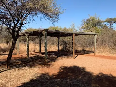 a wooden shelter in the middle of a dirt road at Makhato Bush Lodge 111 in Bela-Bela