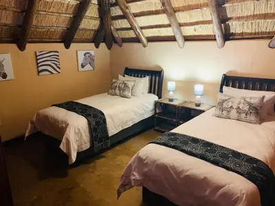 a bedroom with two beds and two lamps in it at Makhato Bush Lodge 111 in Bela-Bela