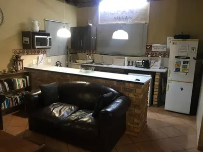 a living room with a leather couch in a kitchen at Mopani Villa in Marloth Park