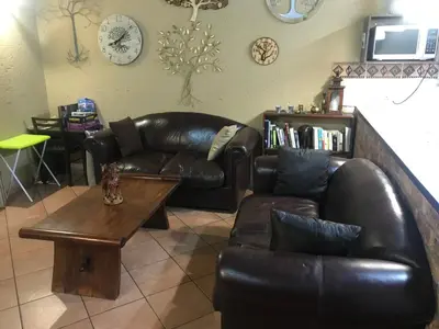 a living room with a leather couch and a coffee table at Mopani Villa in Marloth Park