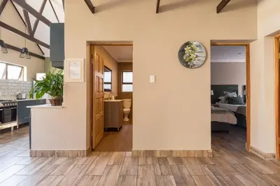 a kitchen and living room with a clock on the wall at Ginger Barn Retreat - 1km from Menlyn in Pretoria