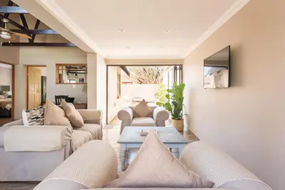 a living room with couches and a table at Ginger Barn Retreat - 1km from Menlyn in Pretoria