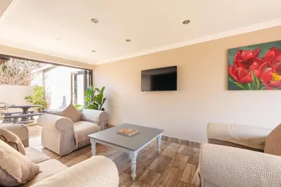 a living room with couches and a tv at Ginger Barn Retreat - 1km from Menlyn in Pretoria