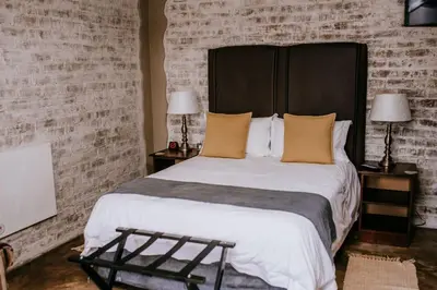 a bedroom with a large bed with a black headboard at La Bendicion in Witbank