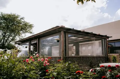 a small house with a window in a garden at La Bendicion in Witbank
