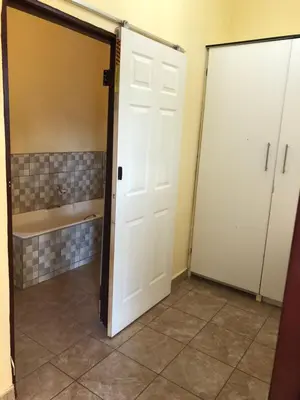 a bathroom with two doors and a tub at Maite Villa Lodge in Thohoyandou