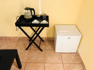 a small black table with a blender and a small refrigerator at Maite Villa Lodge in Thohoyandou