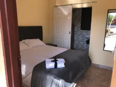a bedroom with a bed with a cross on it at Maite Villa Lodge in Thohoyandou