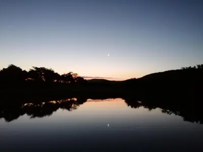 a view of a lake with the sunset in the background at Sabi River Sun Resort in Hazyview