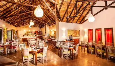 a restaurant with tables and chairs in a room at Sabi River Sun Resort in Hazyview