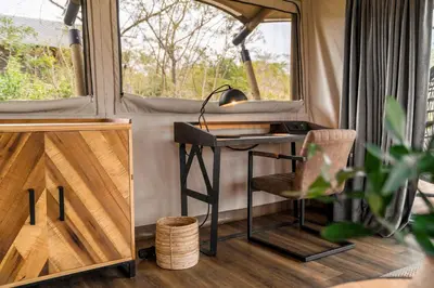 a desk in a tiny house with a window at Mdluli Safari Lodge in Hazyview
