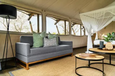 a living room with a couch and a bed at Mdluli Safari Lodge in Hazyview