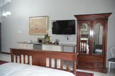 a bedroom with a wooden entertainment center with a flat screen tv at 64 on Malabor in Pretoria