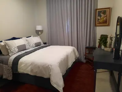 a bedroom with a bed and a desk and a window at 64 on Malabor in Pretoria
