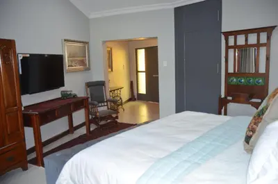 a bedroom with a bed and a flat screen tv at 64 on Malabor in Pretoria