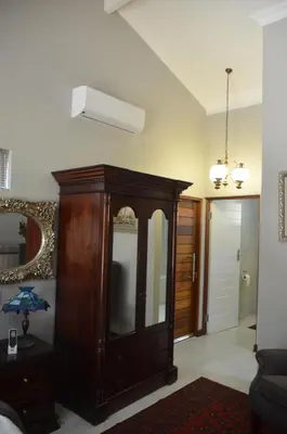 a living room with a dresser and a mirror at 64 on Malabor in Pretoria