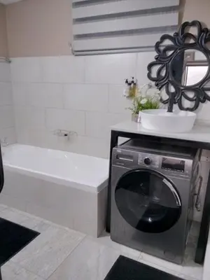 a bathroom with a washing machine and a bath tub at High Court Self Catering Apartments in Nelspruit