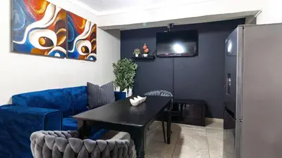 a living room with a table and a blue couch at High Court Self Catering Apartments in Nelspruit