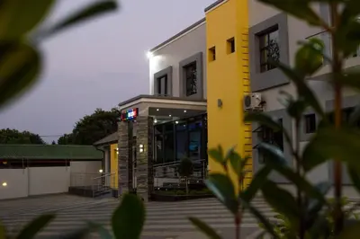a yellow and white building with a lot of windows at Aqua Stone guest house in Nelspruit