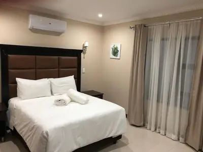 a bedroom with a bed with two towels on it at Aqua Stone guest house in Nelspruit