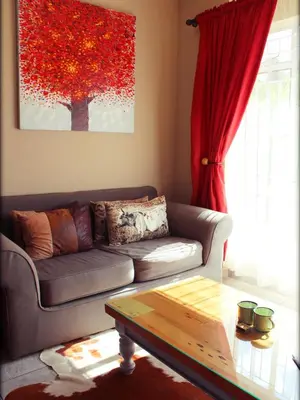 a living room with a couch and a table at Aqua Terra Guest House in Lydenburg