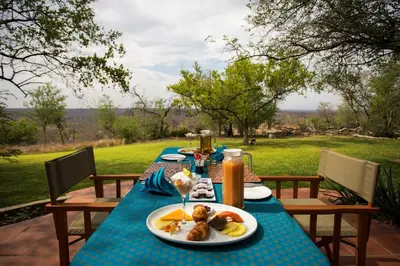 a table with a plate of food on it at isiLimela Game Lodge in Hoedspruit