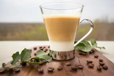 a drink in a glass sitting on a table with coffee beans at isiLimela Game Lodge in Hoedspruit