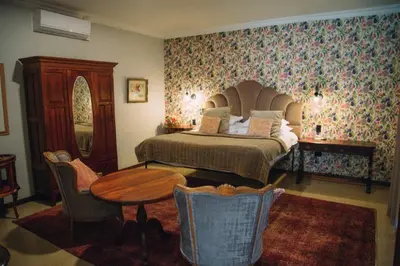 a bedroom with a bed and a table and chairs at The Bohemian Guesthouse in Tzaneen