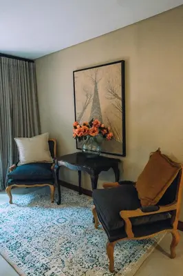 a living room with a table and chairs and a vase of flowers at The Bohemian Guesthouse in Tzaneen