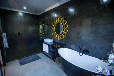 a large bathroom with a tub and a mirror at The Bohemian Guesthouse in Tzaneen